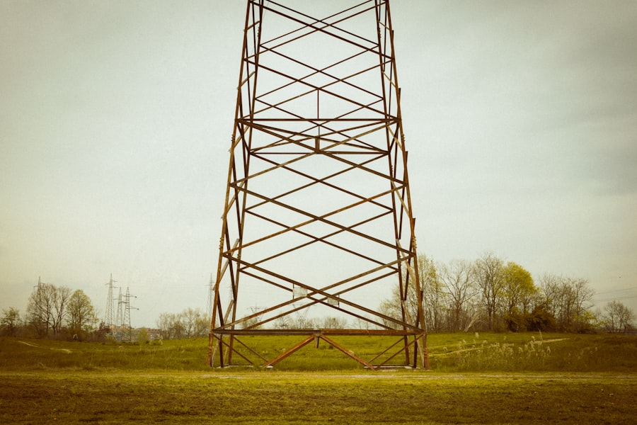 Tall metal tower on lush green field — tower antenna array for large-scale electro culture deployment